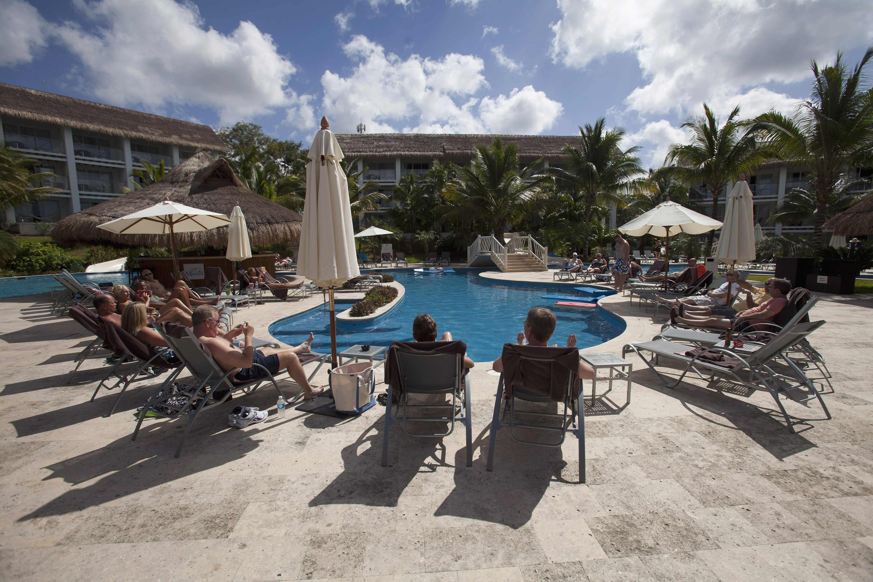 Tourists sunbathe around a pool at a hotel in Cozumel