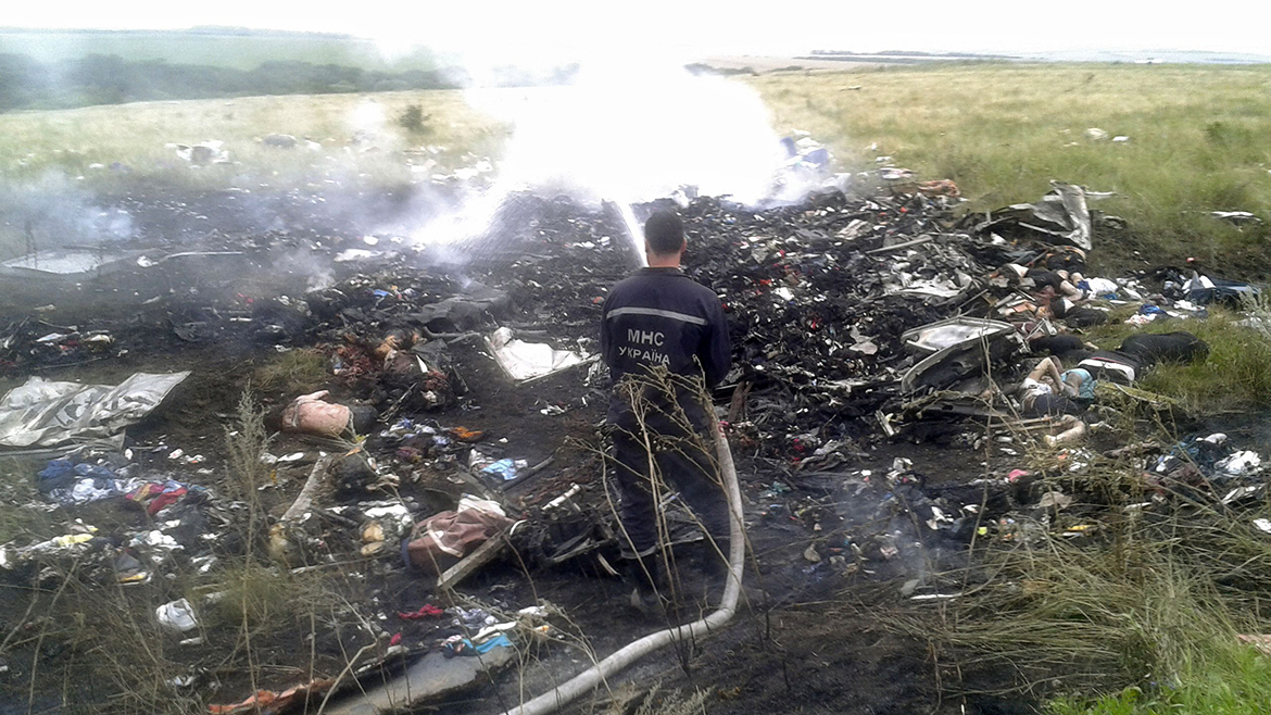 Man works at putting out a fire at the site of a Malaysia Airlines Boeing 777 plane crash in the settlement of Grabovo in the Donetsk region
