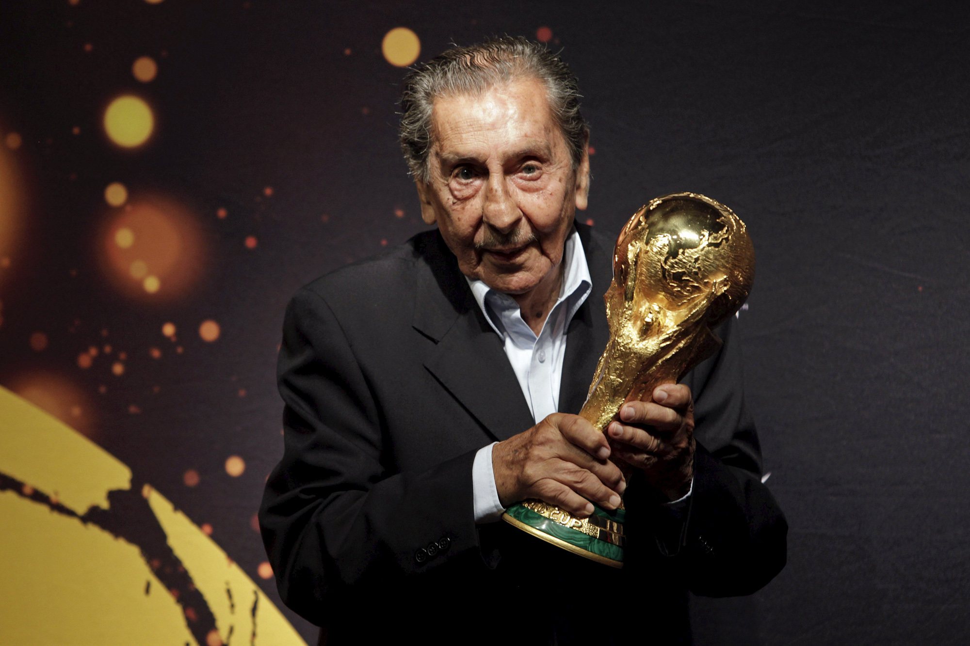 Former Uruguayan soccer player Alcides Ghiggia, famed for his role in the final 1950 World Cup match between Uruguay and Brazil, poses with the FIFA World Cup trophy during the 2014 FIFA World Cup Trophy Tour in Montevideon in this January 16, 2014 file picture.  Ghiggia, who scored the legendary goal for the Uruguayan national team to win the 1950 World Cup , died at the age of 88 on July 16, 2015 of a heart attack, local media reported on the 65th anniversary of the conquest that silenced the Maracana. Picture taken July 16, 2014.  REUTERS/Andres Stapff/Files
