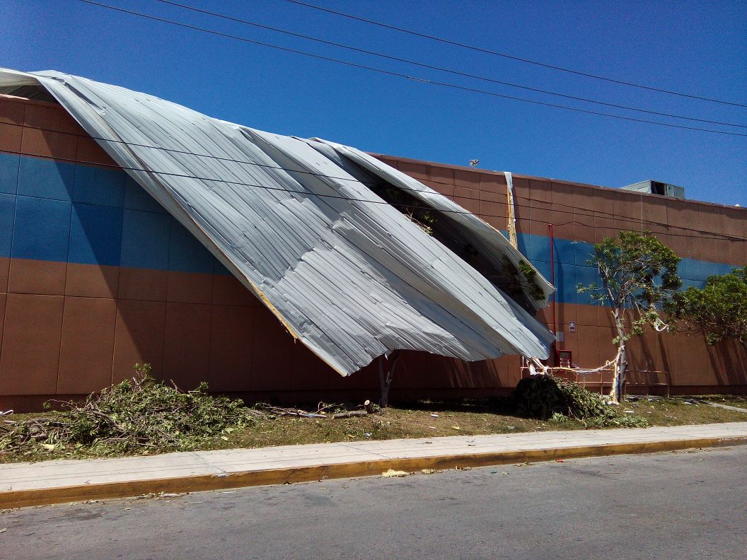 Así lucía este jueves el techo desprendido en la tienda Wal Mart de la Gran Plaza de Cancún, con parte de la estructura aún colgando sobre la vía pública.
