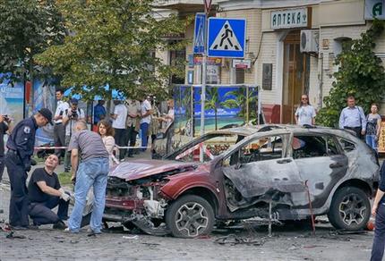 Expertos forenses examinan los restos de un vehículo quemado en Kiev, Ucrania, el miércoles 20 de julio de 2016. El medio en internet más destacado del país, Ukrainska Pravda, anunció el miércoles que su periodista estrella, Pavel Sheremet, murió por la explosión de una bomba en su vehículo. (AP Foto/Efrem Lukatsky)
