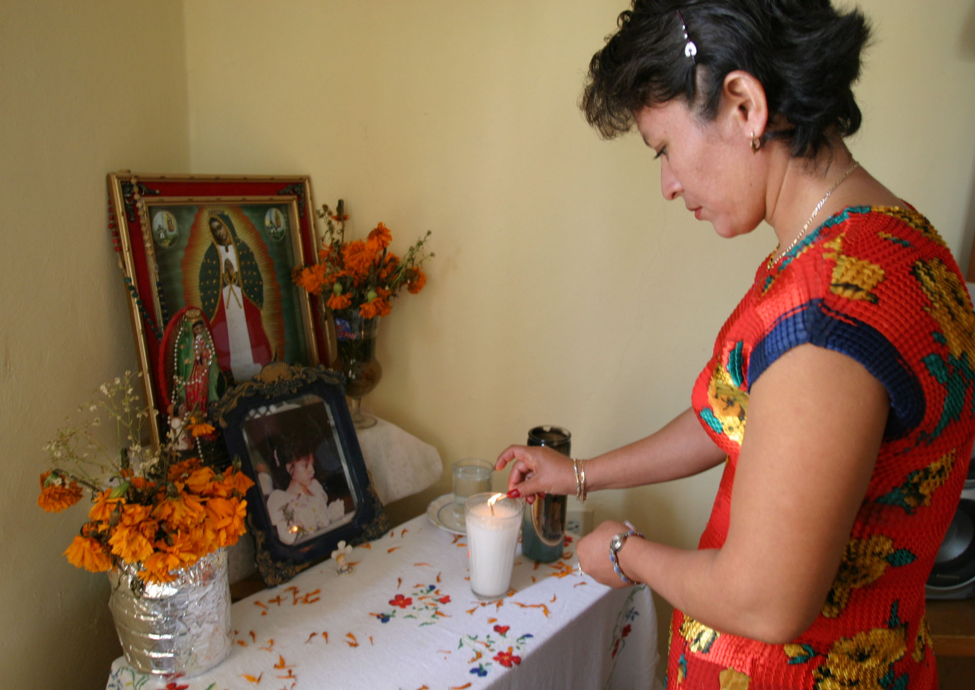 En la foto, la señora Ana Isabel Rodríguez, madre de la joven Mayra Beatriz Ayuso Rodríguez, al encender una veladora a la memoria de su hija cuando se cumplieron 5 años de su muerte.